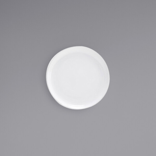 A Front of the House Harmony bright white porcelain plate with a small amount of food on it on a gray surface.