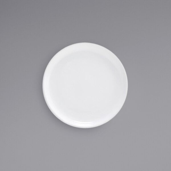 A Front of the House bright white porcelain plate with a white rim on a gray surface.