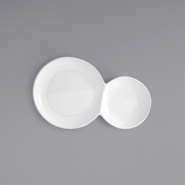 A white porcelain plate with two compartments.