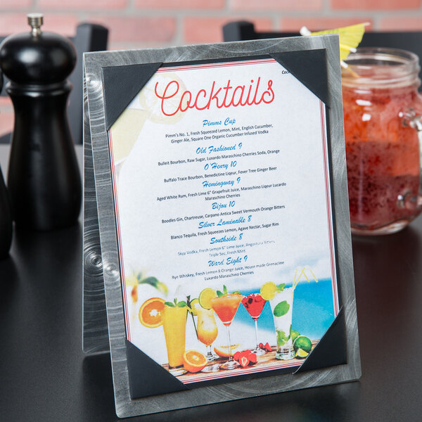 A Menu Solutions Alumitique aluminum table tent holding a menu of drinks on a table.