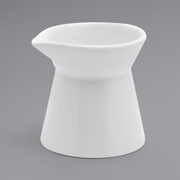 A white ceramic Front of the House Mod Cinched creamer with a handle and a white rim.