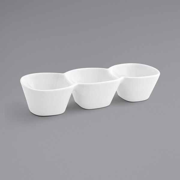Three bright white porcelain bowls with three compartments stacked on top of each other.