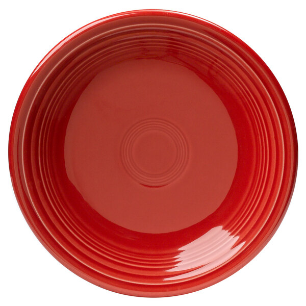 A close-up of a Fiesta Scarlet china salad plate with a circular pattern on the rim.