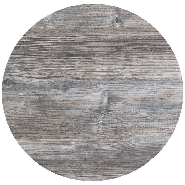 A BFM Seating Tribeca round driftwood composite laminate table top.