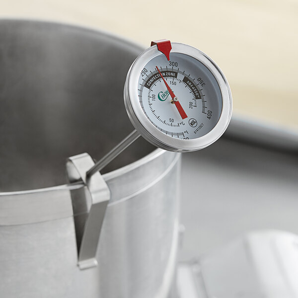 A Choice 12" Candy / Deep Fry Probe Thermometer in a pot of liquid.