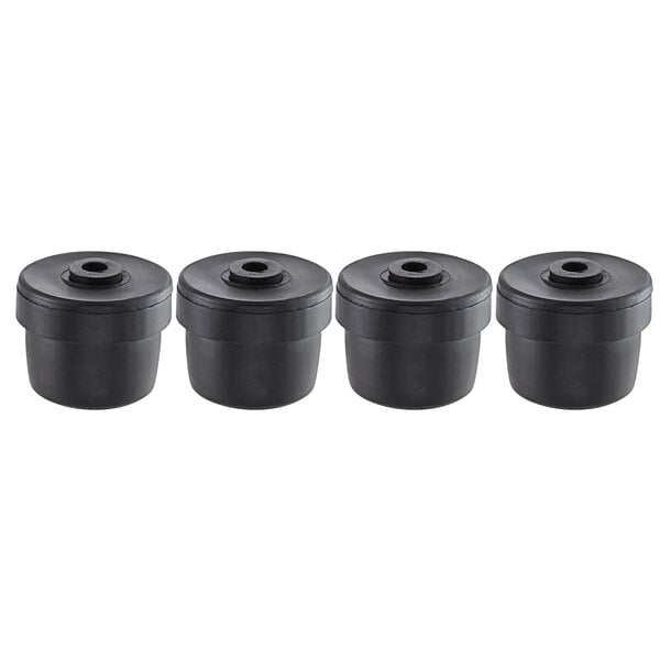 A row of four black Lancaster Table & Seating plastic glides with lids on them.