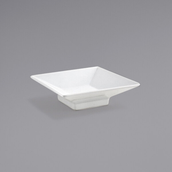 A Front of the House bright white square porcelain sauce dish with a small handle.