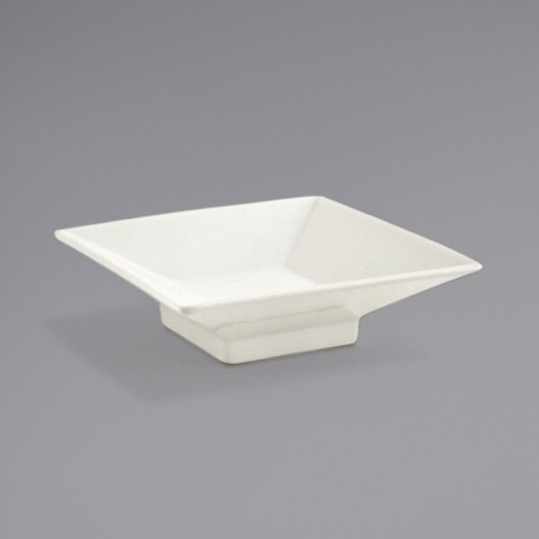 A Front of the House Catalyst Kyoto European White Square Porcelain Footed Sauce Dish with a handle on a gray surface.