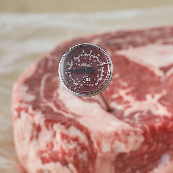 A red AvaTemp pocket probe thermometer gauge inserted in raw meat.
