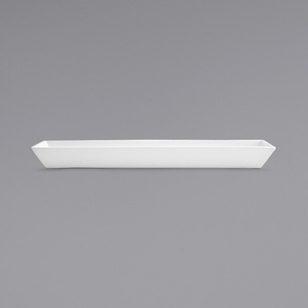 A white rectangular porcelain server with a long handle.