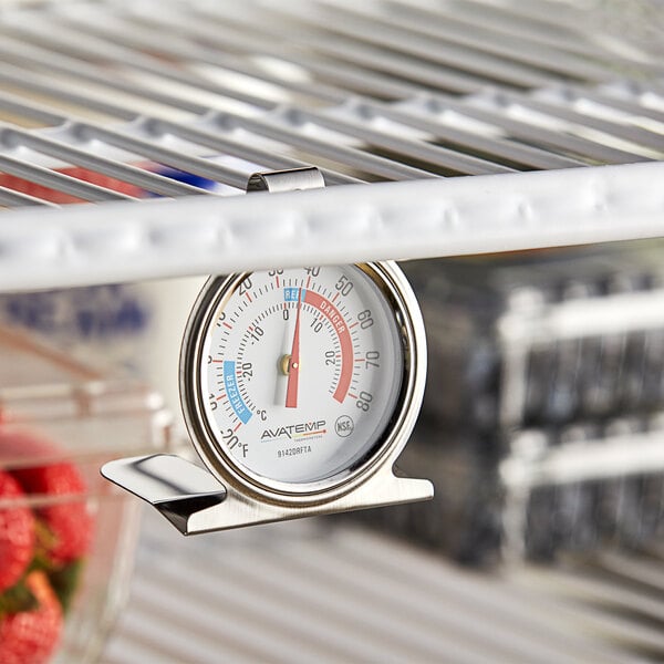 An AvaTemp refrigerator / freezer thermometer hanging from a shelf.