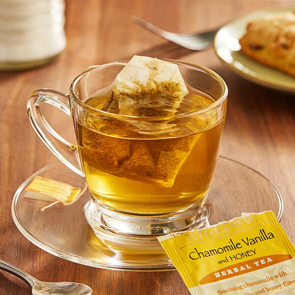 A glass cup of Bigelow Chamomile Vanilla and Honey tea with a tea bag in it.