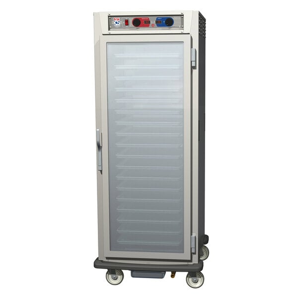 A stainless steel Metro C5 holding and proofing cabinet with clear glass doors on wheels.