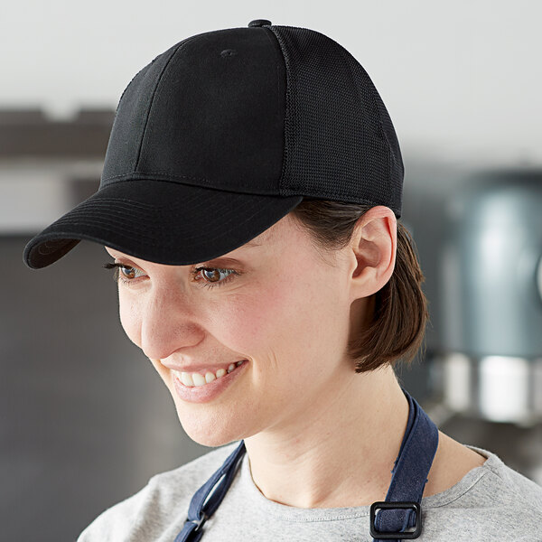 A woman wearing a black Henry Segal cap with mesh back.