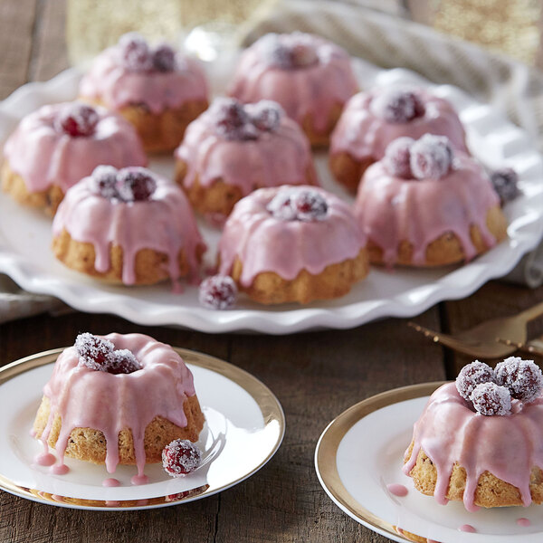 A plate of Wilton mini fluted bundt cakes with pink frosting.