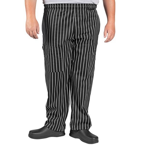 A person wearing Uncommon Cargo Chalk Stripe chef pants with white stripes.