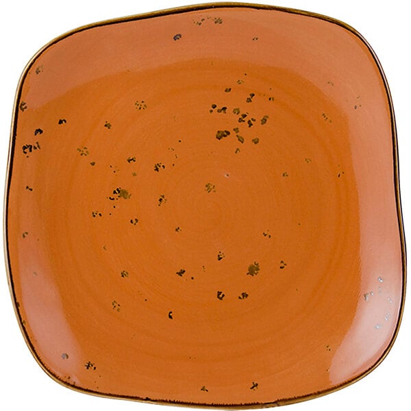 A white square Tuxton china plate with an orange geode design.