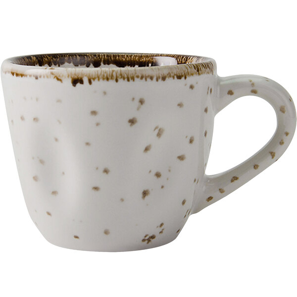 A white coffee cup with brown speckles.