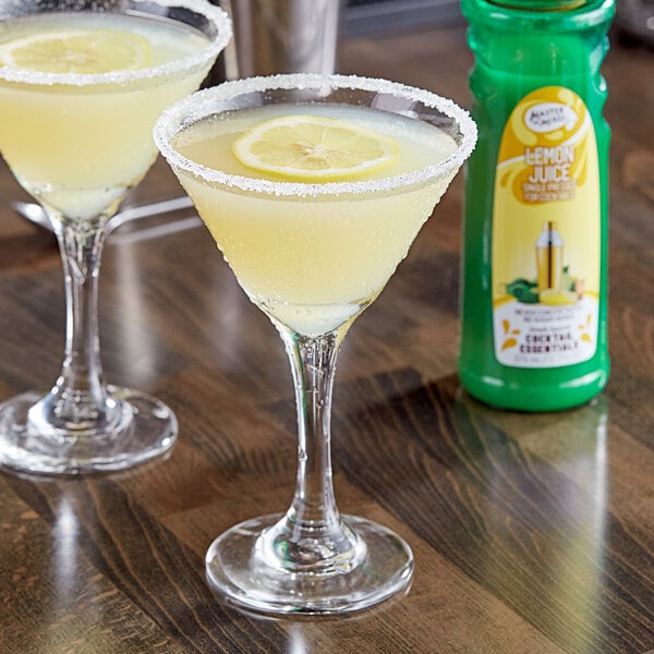 Two glasses of lemon juice with Master of Mixes Single Pressed Lemon Juice on a table.