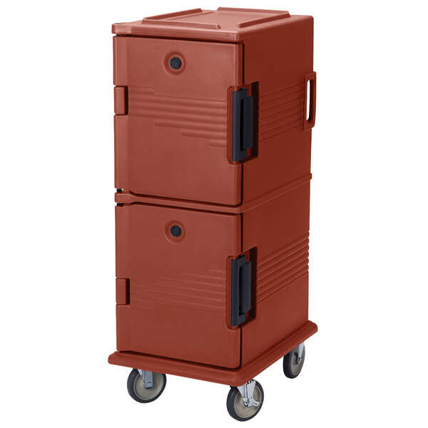 A red plastic Cambro food pan carrier with heavy-duty casters.