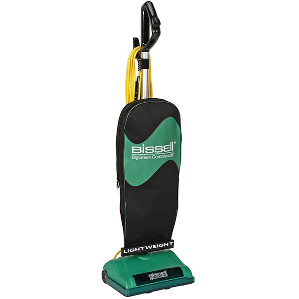 A black and green Bissell upright vacuum cleaner with a bag.