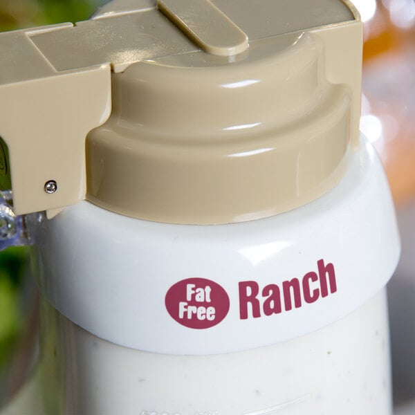 A Tablecraft white plastic dispenser collar with maroon lettering on a white bottle of ranch dressing.