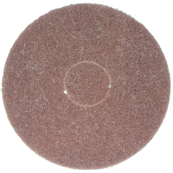 A brown circular Bissell scrubbing pad with a white circle in the middle.