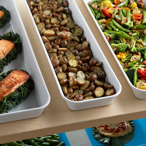 A white Cambro market pan filled with a variety of vegetables on a buffet counter.