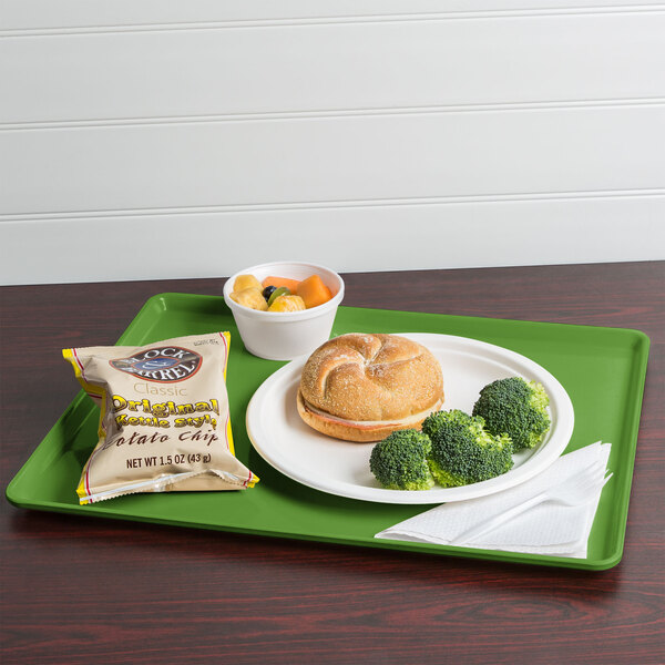 A Cambro lime-ade dietary tray with a sandwich, broccoli, and a bag of potato chips on it.