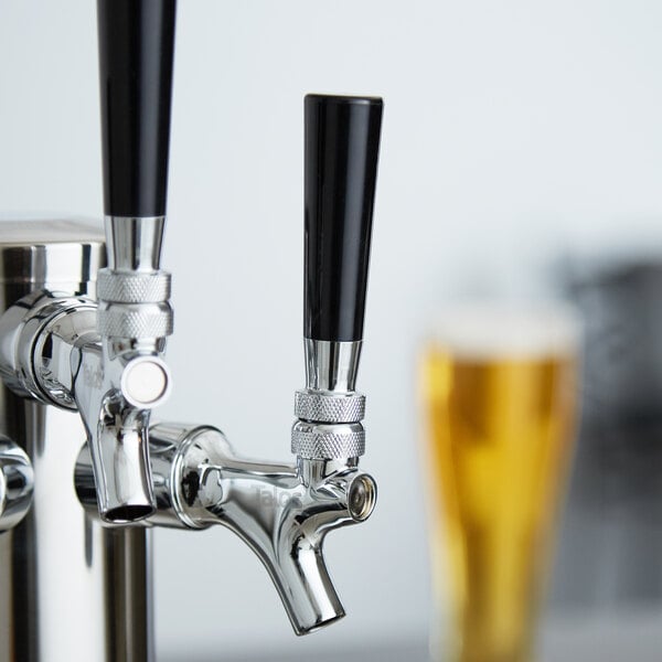 A black plastic beer tap handle on a silver tap.