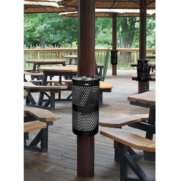 A black Ex-Cell Kaiser round waste receptacle with lid on a table in a picnic area.
