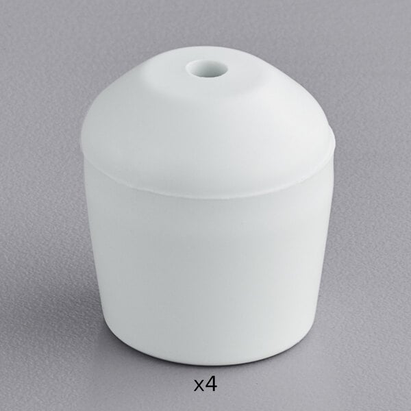 A white plastic container with a white round cone-shaped object inside with four holes.