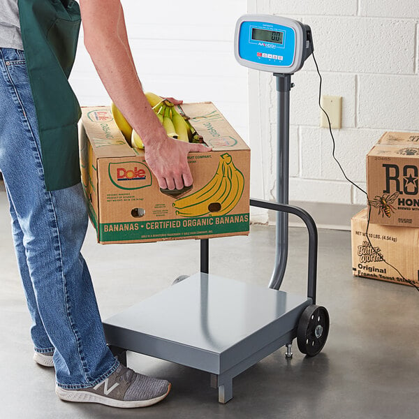A man weighing a box of bananas on an AvaWeigh digital receiving scale.