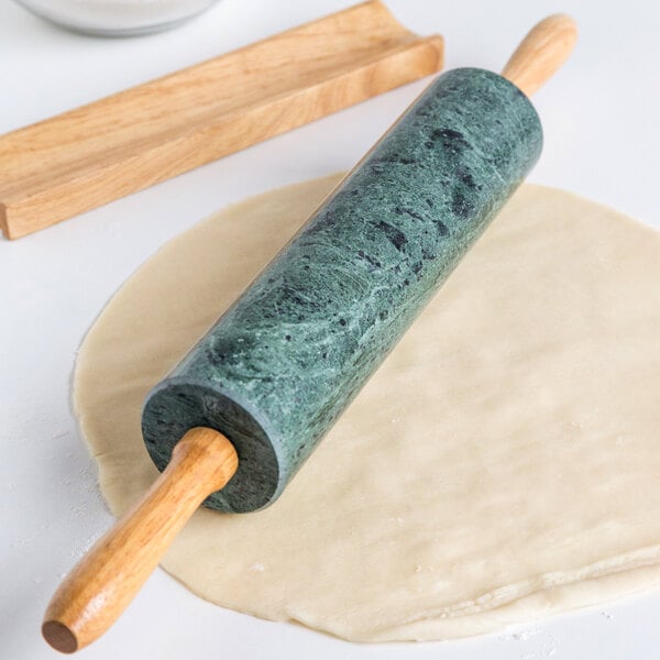 A Fox Run rolling pin with green marble on the ends and wooden handles.