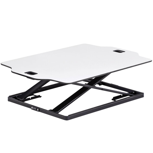 A Safco white sit-stand desktop desk on a white table with black legs.