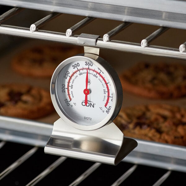 A CDN ProAccurate oven thermometer on a rack of cookies.