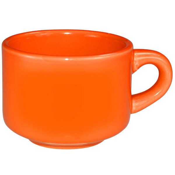 An orange International Tableware stoneware cup with a handle.