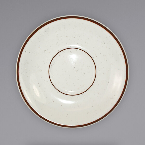 An International Tableware Granada ivory saucer with a brown speckled rim.
