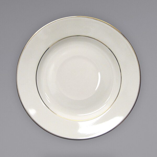 An International Tableware ivory stoneware saucer with a gold rim.