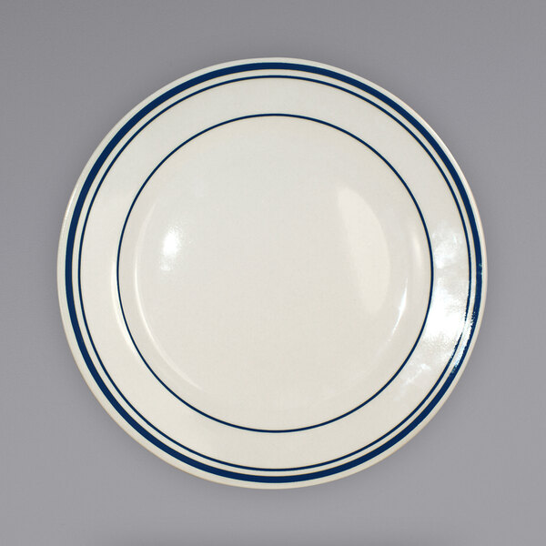An ivory stoneware plate with blue lines on the rim.