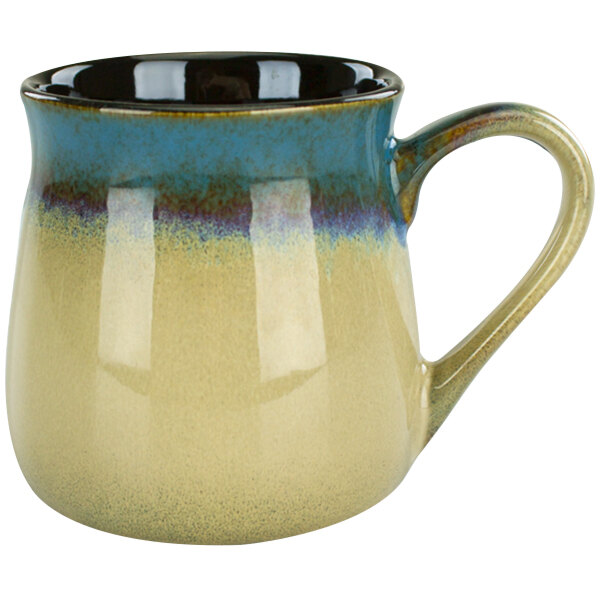 A close-up of a blue and tan stoneware mug with a handle.