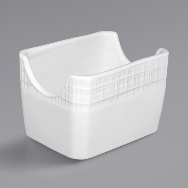 A bright white porcelain sugar packet holder with a checkered design on the sides.