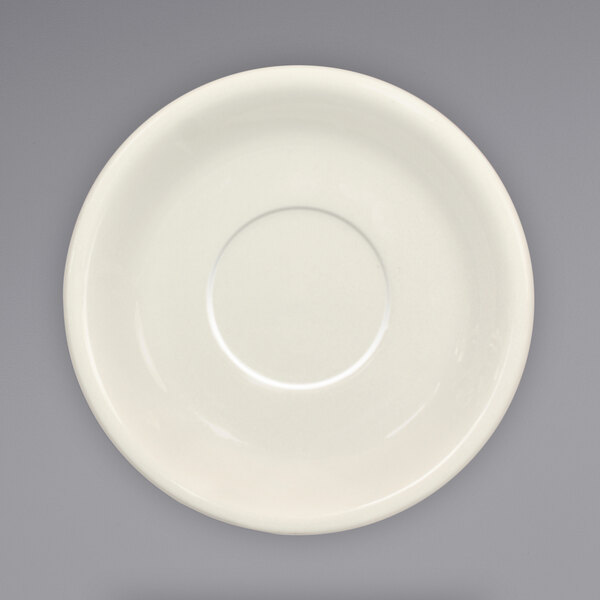 An ivory stoneware saucer with a circle in the middle.