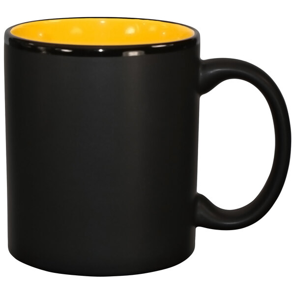 A yellow stoneware mug with a black rim and interior with a C-shaped handle.