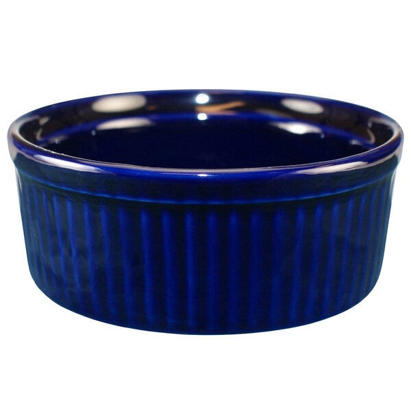 A cobalt blue stoneware fluted ramekin on a table.