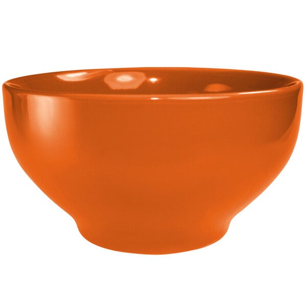 An orange International Tableware stoneware bowl with a white background.