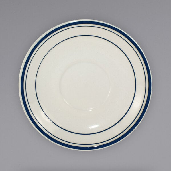 An ivory Catania saucer with blue bands around the rim.