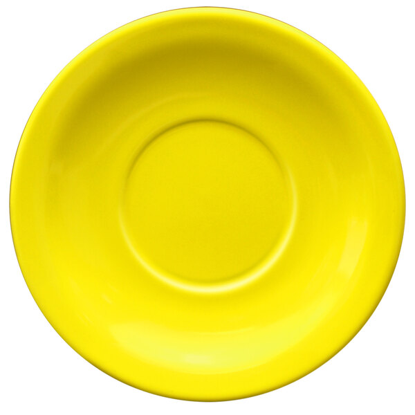 A yellow stoneware saucer with a circle in the middle.