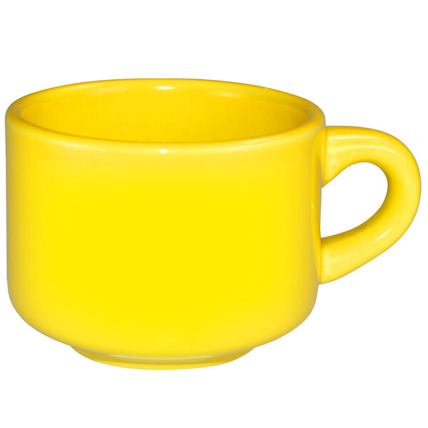 A yellow International Tableware stoneware cup with a handle.