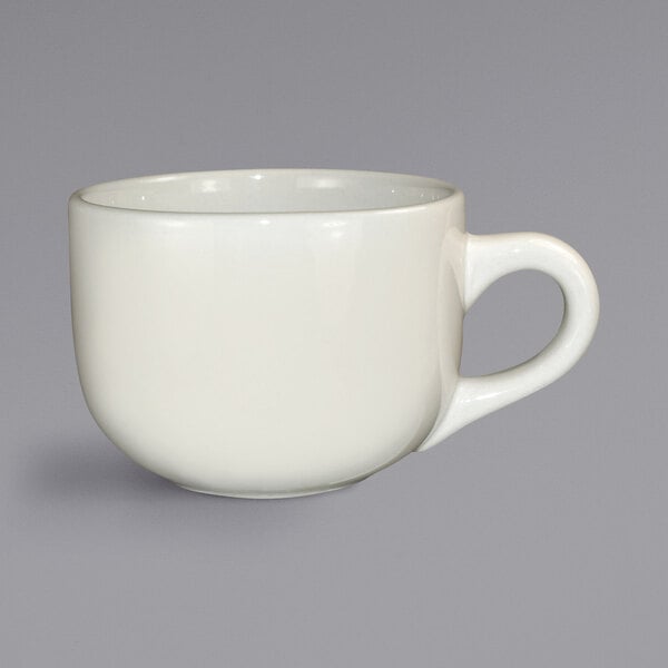 An ivory stoneware latte cup with a handle.